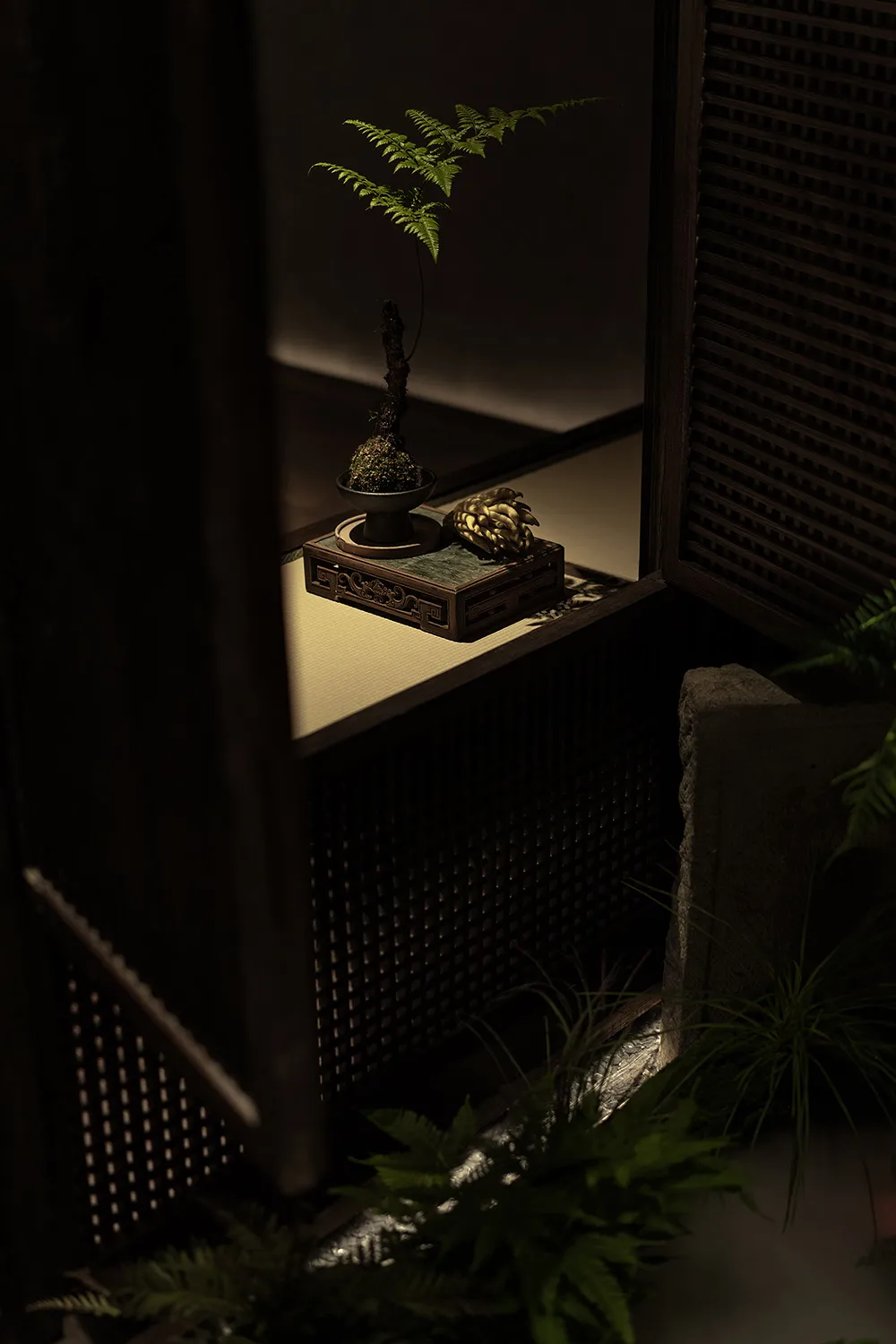 A traditional indoor decoration featuring a wooden cabinet with a plant and decorative items.