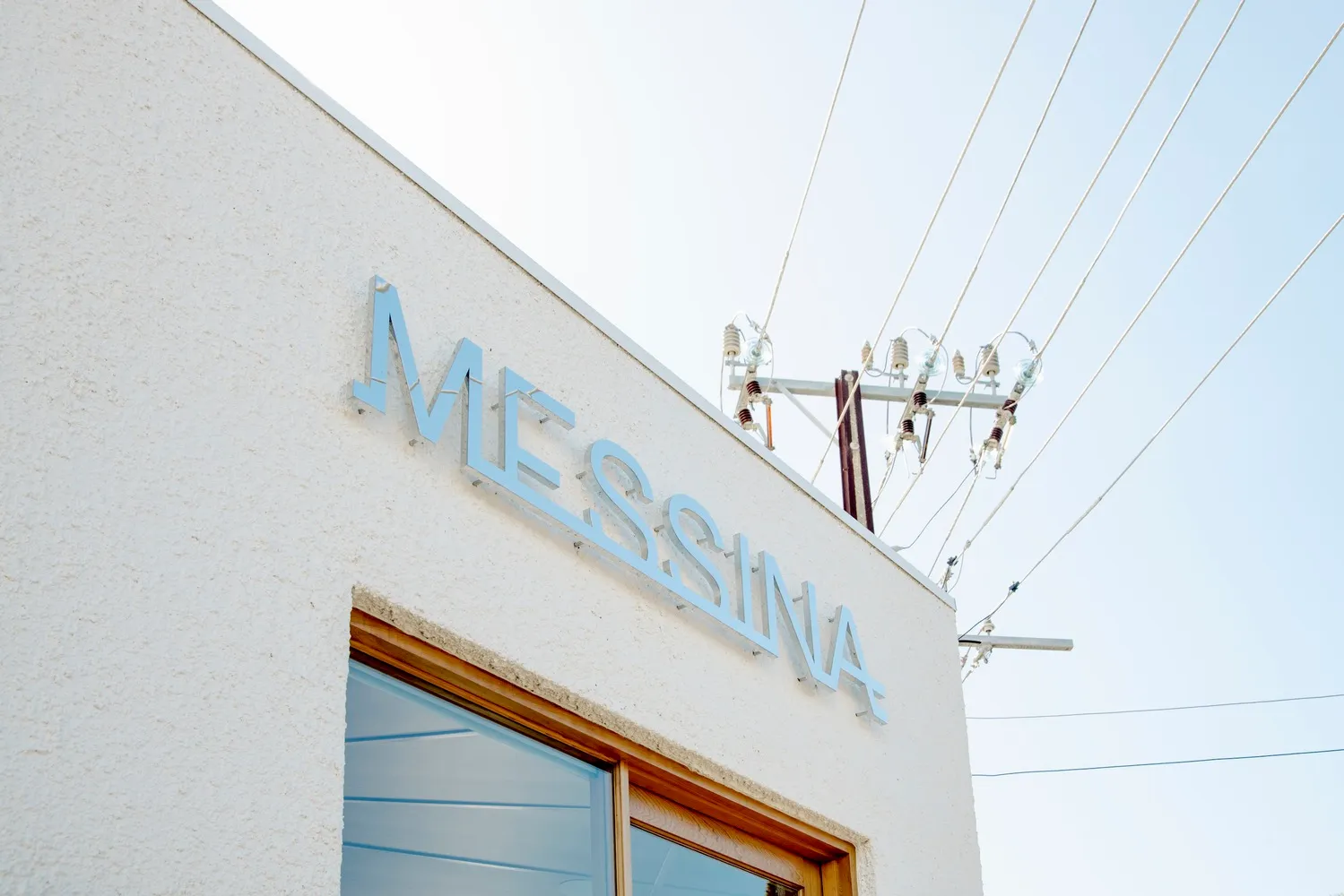 梅西納建築外觀擁有乾淨的白牆，搭配藍色「Messina」招牌