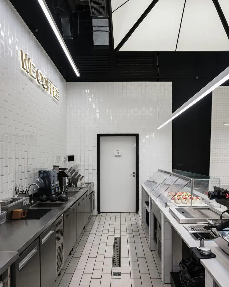 Modern minimalist cafe interior with white tiles and metallic fixtures