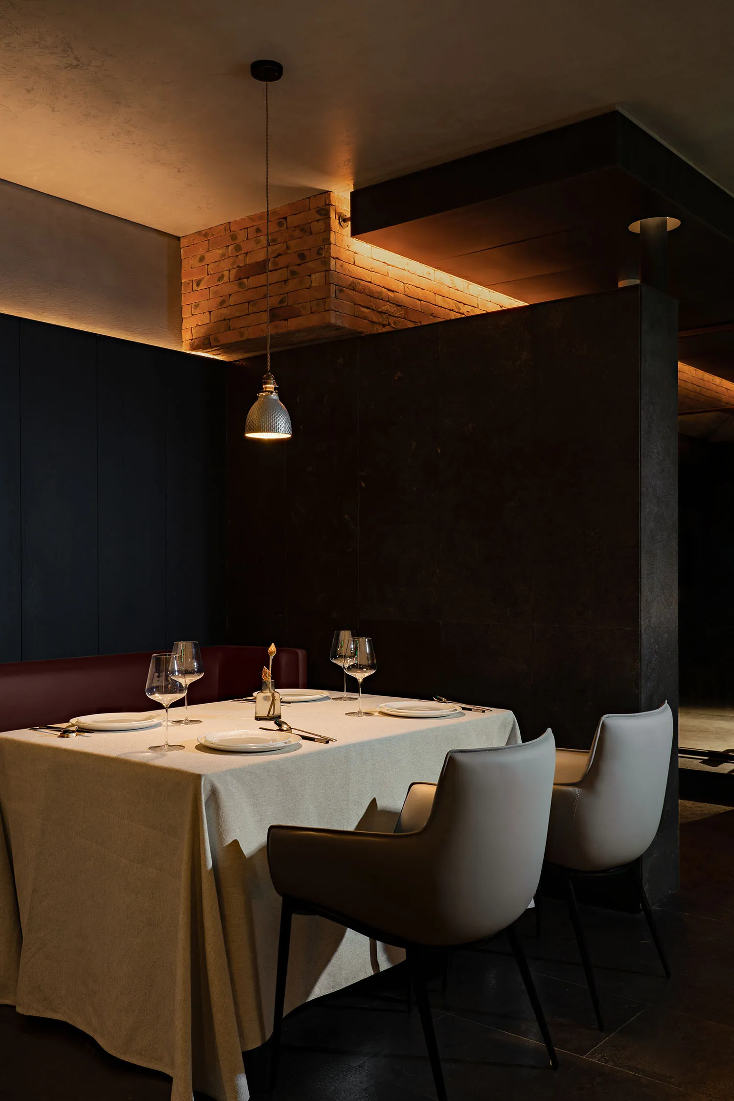 A modern restaurant setting with tables, chairs, and brick wall