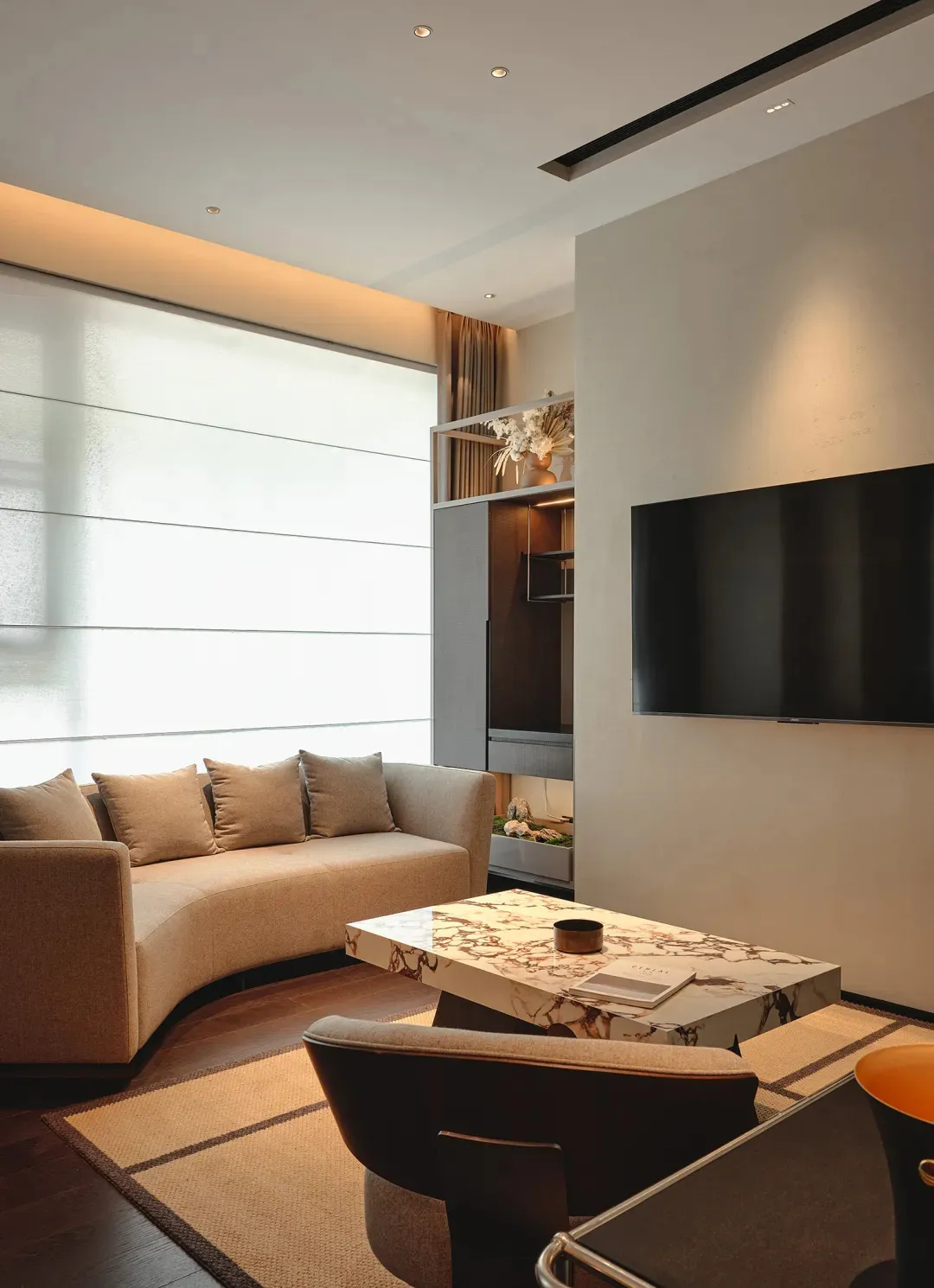 A modern living room featuring a contemporary sofa, marble coffee table, and concrete accents.