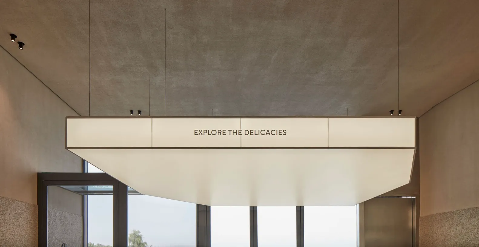 Modern minimalist lobby with concrete ceiling.