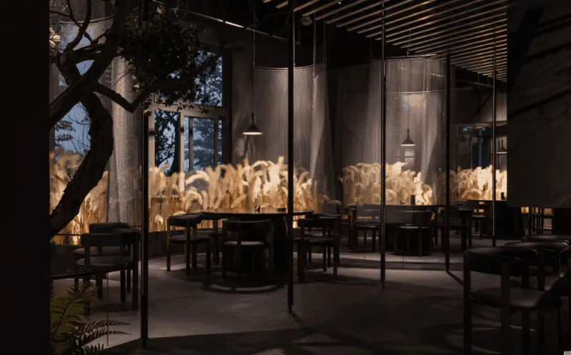 Industrial restaurant interior with metal furniture, glass partitions, and concrete floor.