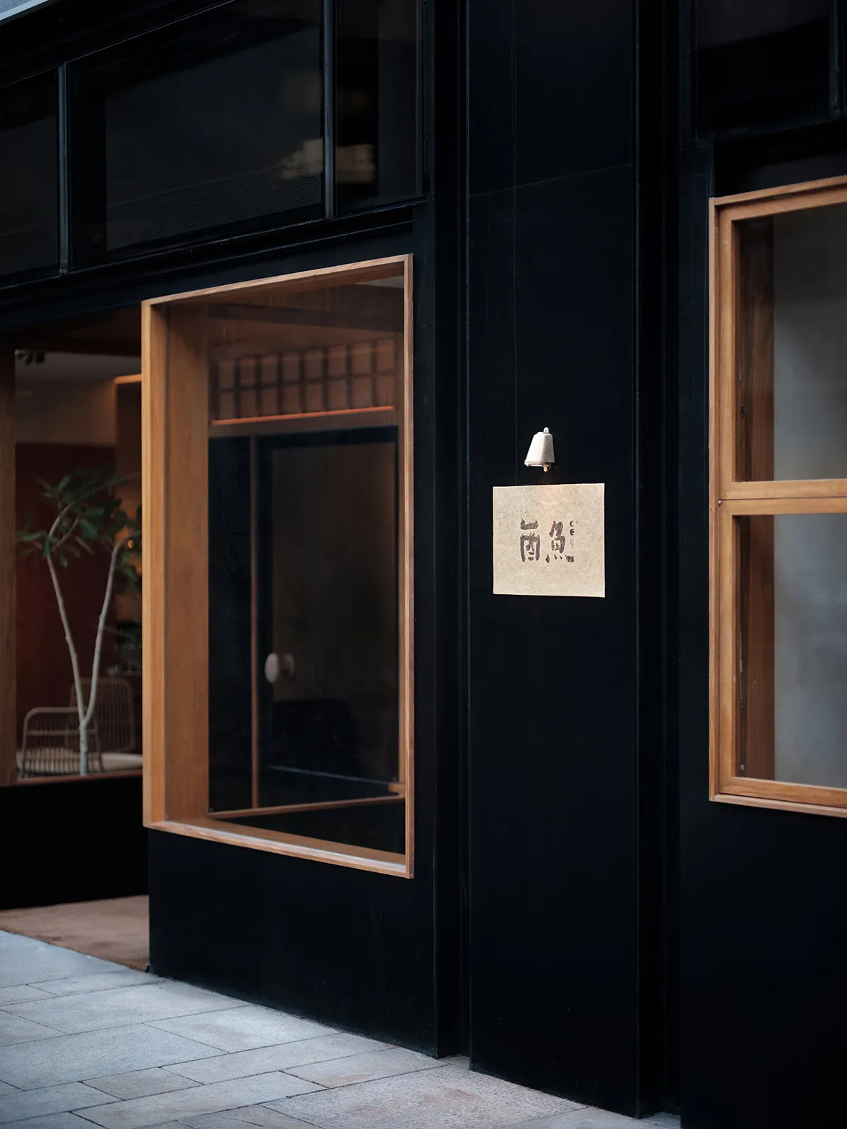 現代餐廳店面，黑色牆面搭配橘色點綴，並有大型玻璃窗。