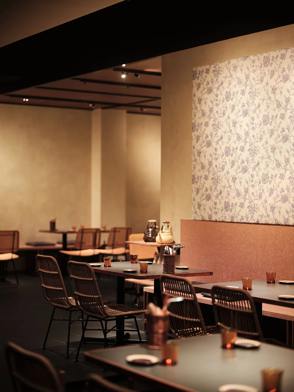 餐廳室內視圖,展示木質餐桌、布料座椅與花卉壁紙。