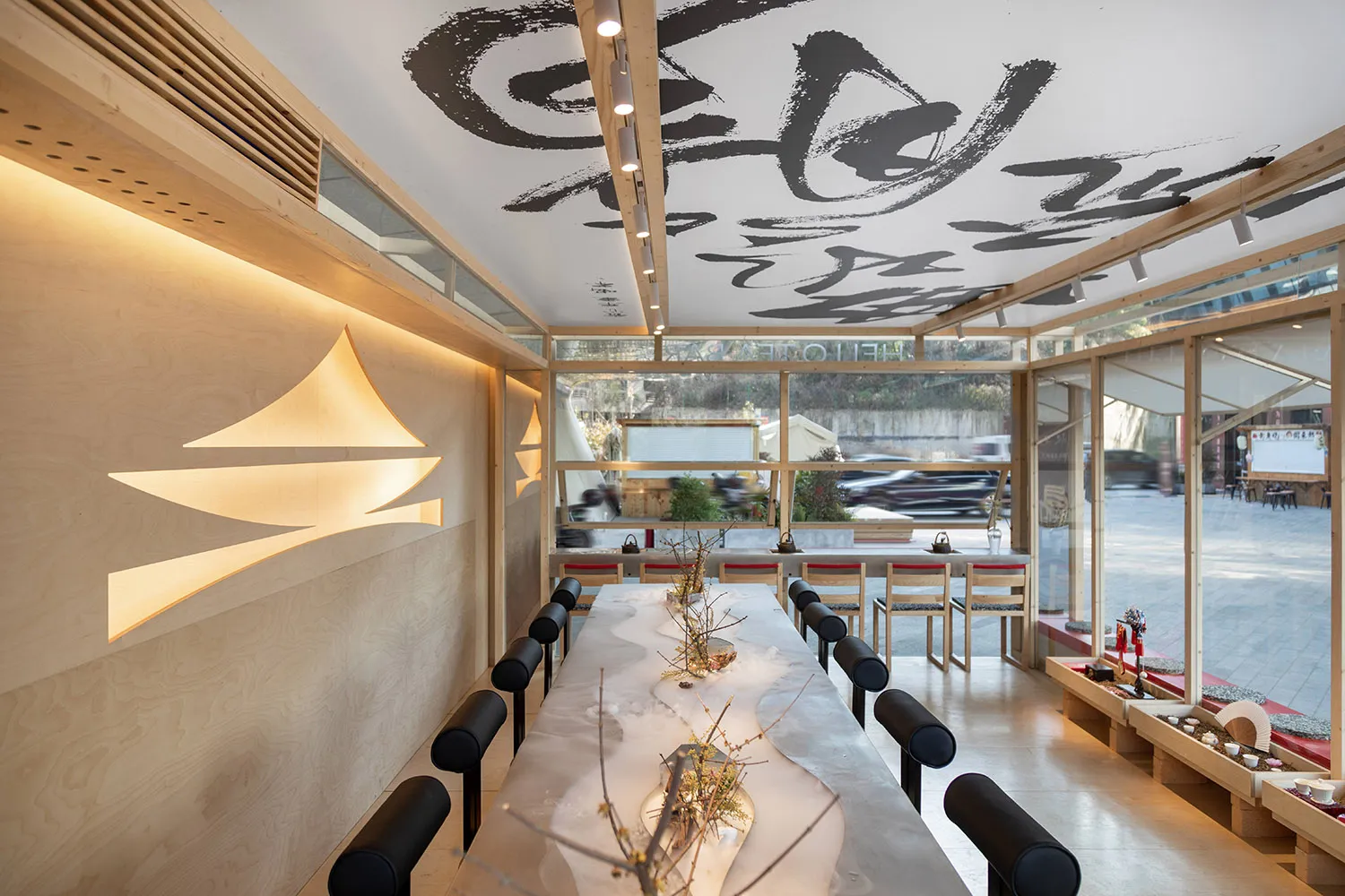 Modern restaurant interior with wooden tables, glass walls, and minimalist design features.