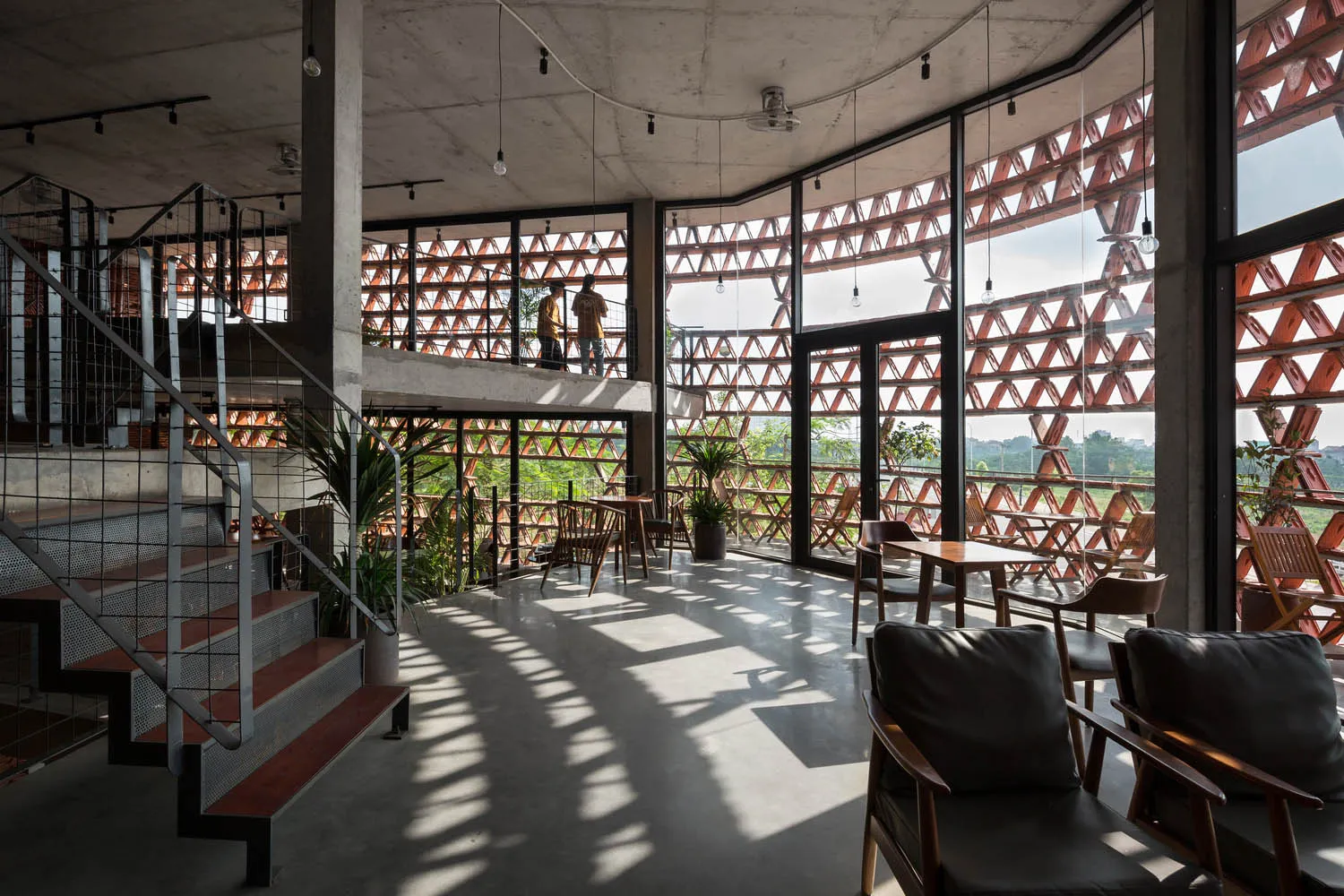 A modern industrial interior with concrete flooring, glass walls, and industrial lighting.
