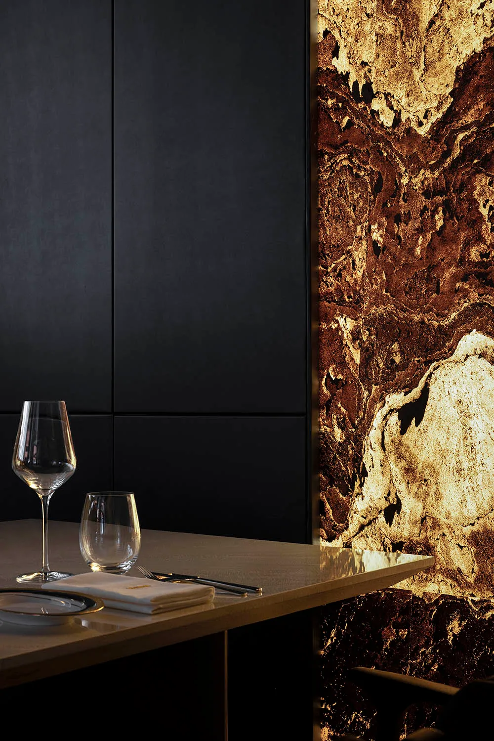 Modern restaurant interior with marble walls and minimalist design.
