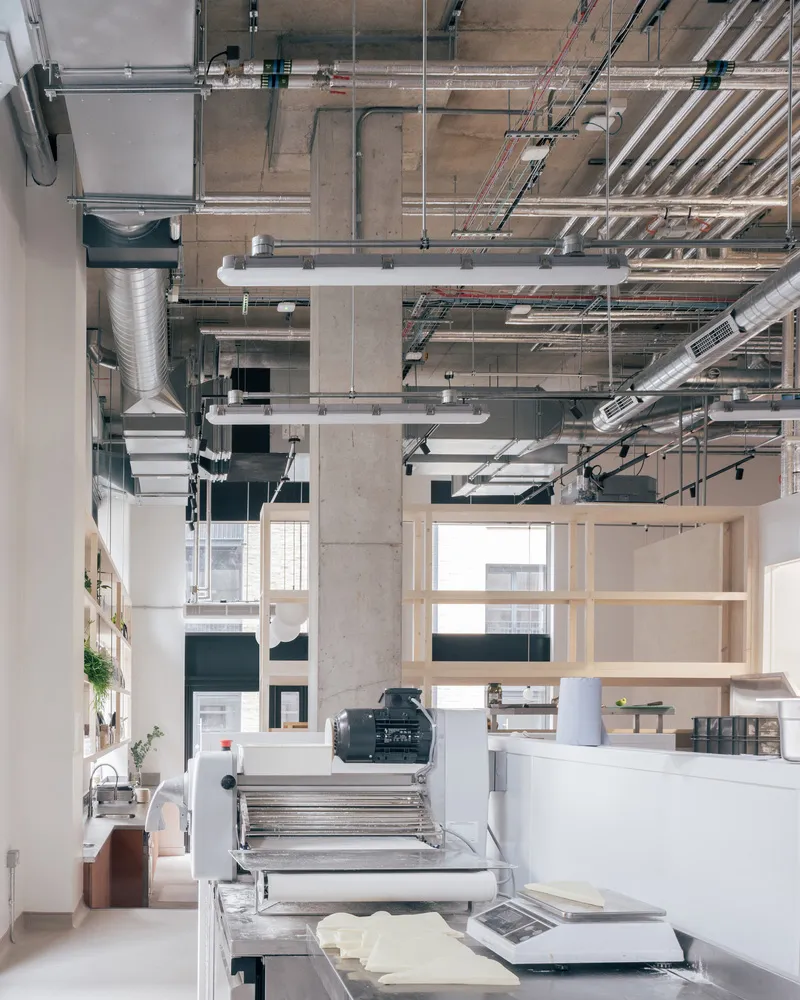 A modern industrial bakery kitchen with steel, concrete, and glass materials.
