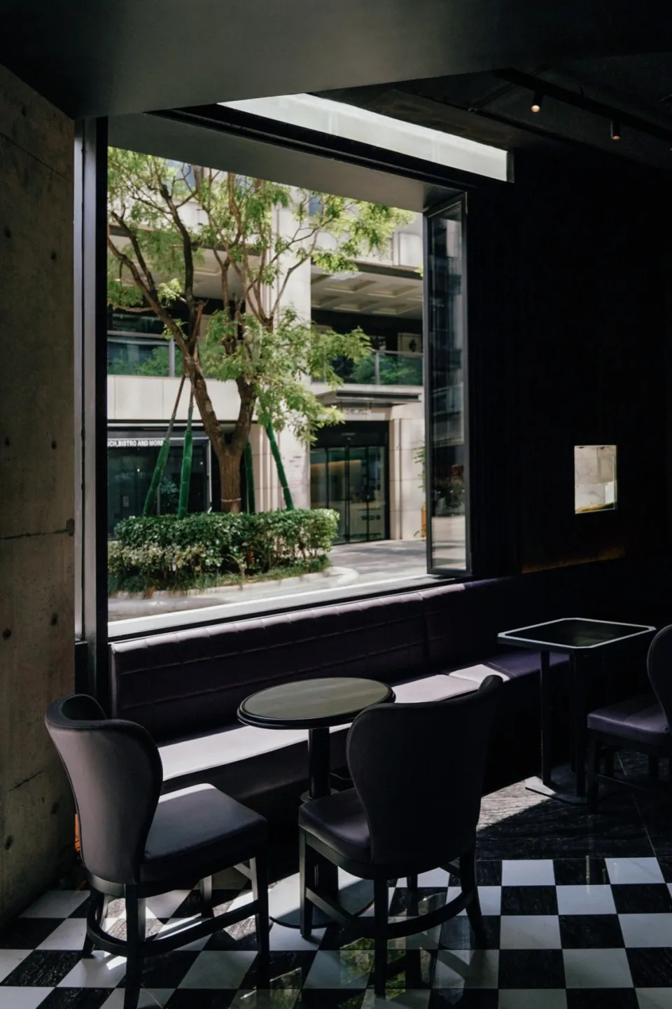 Modern cafe interior with glass wall, black table, and white flooring.