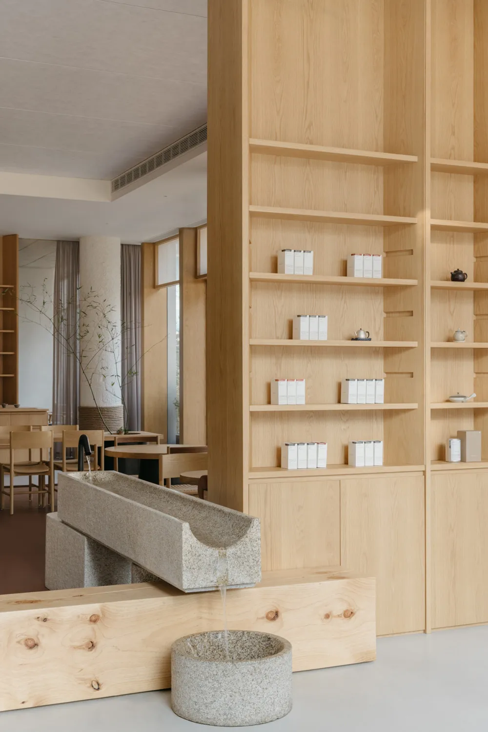 A minimalist retail space featuring wooden shelves with products displayed.