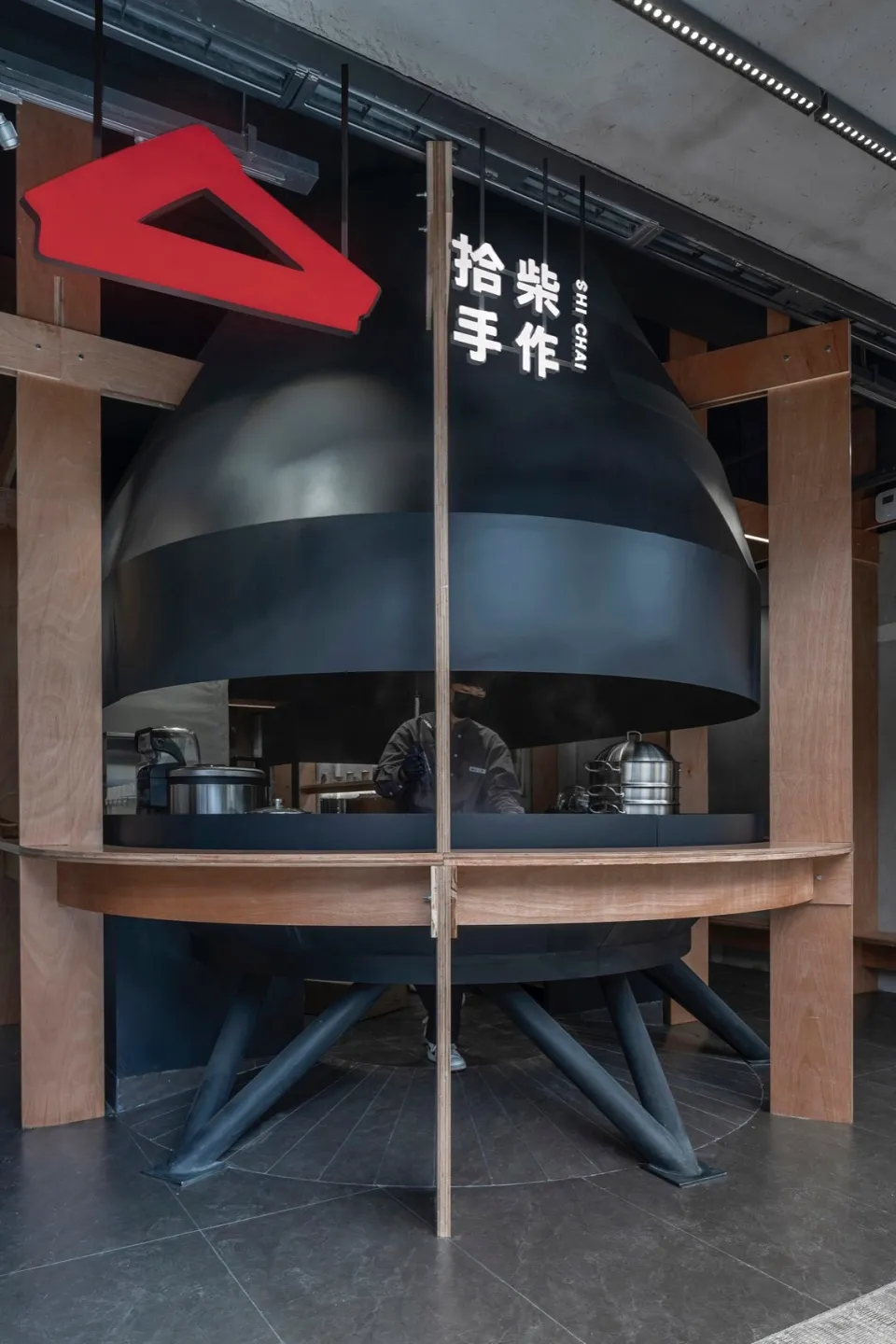 現代餐廳室內,展示黑色木質固定櫃與黑色圓頂結構。