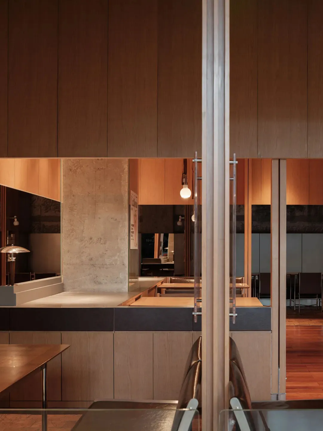 Modern restaurant interior featuring wooden paneling and sleek furniture.