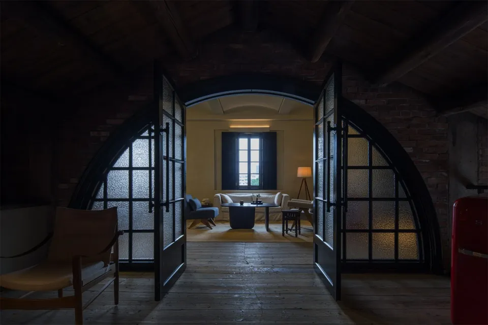 Interior design featuring a minimalist living room with brick arches and glass doors.