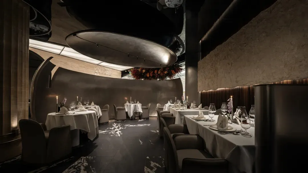 Modern restaurant interior with metallic ceiling, wood walls, and fabric seating.