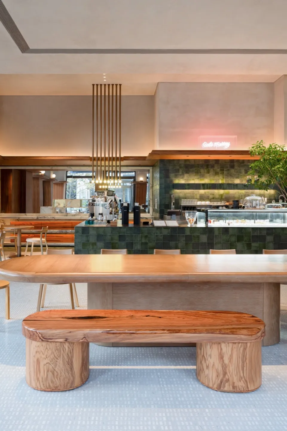 Industrial-style cafe interior featuring green tiles and wood furniture.