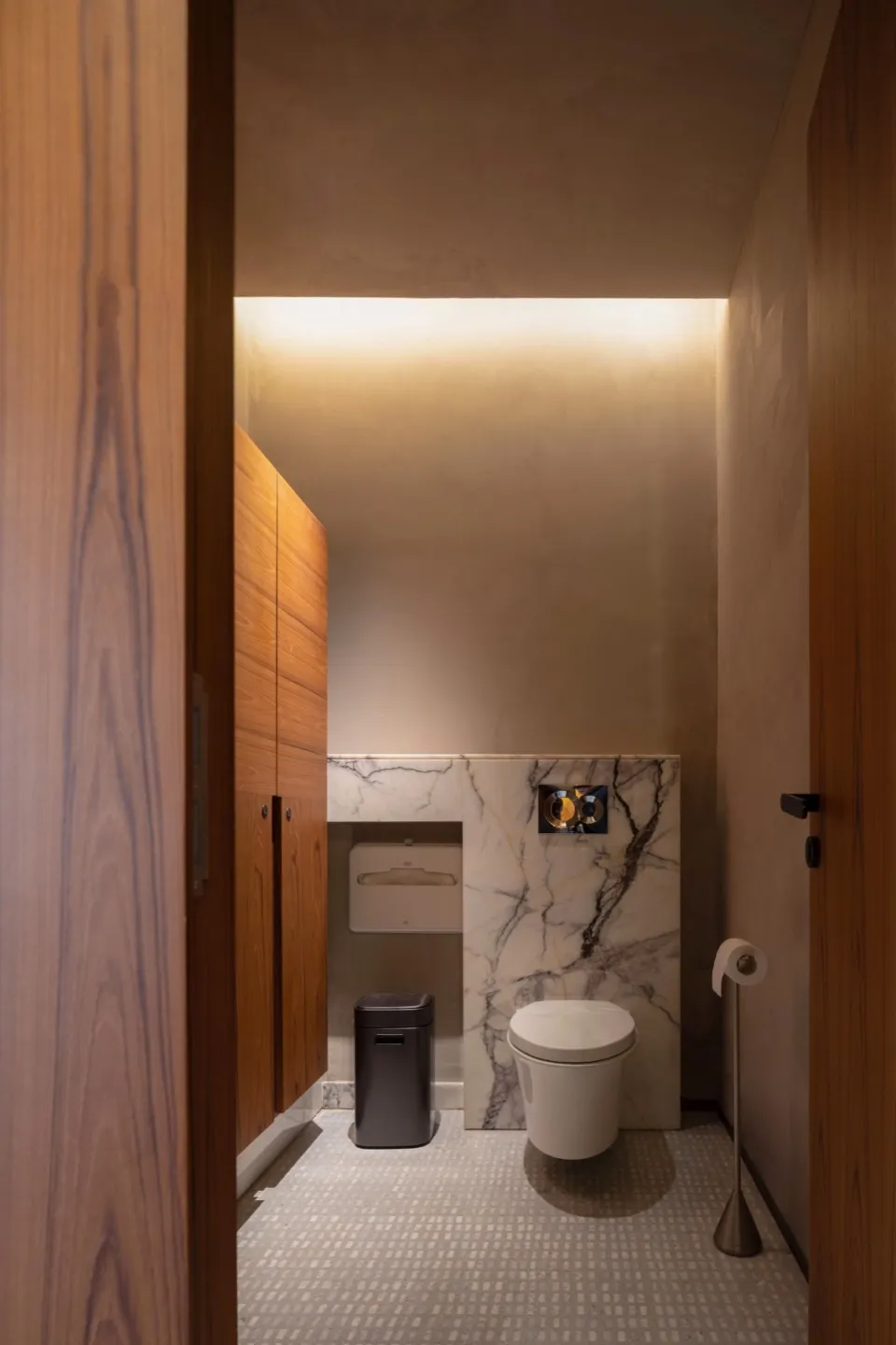 Modern bathroom featuring a concrete wall, white marble tiles, and minimalist design.