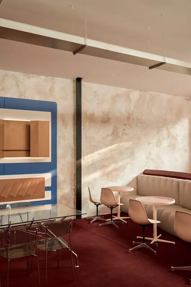 A modern cafe interior featuring concrete walls and metal seating.