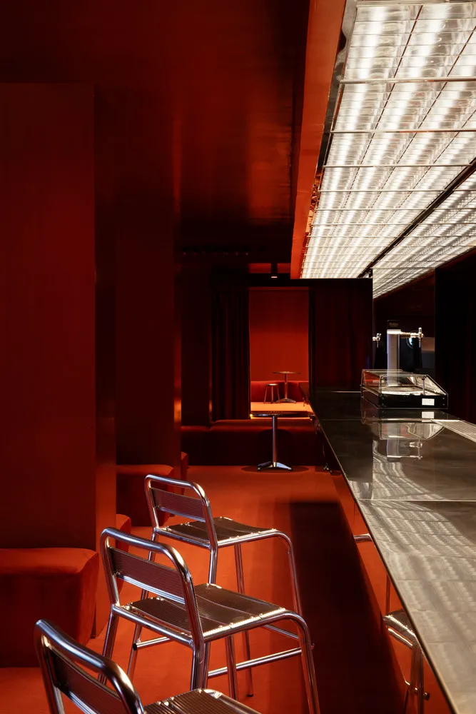 Modern bar area with red interior and metallic seating