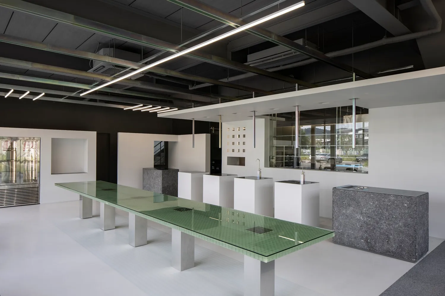 A modern, minimalist workspace featuring concrete and glass elements.