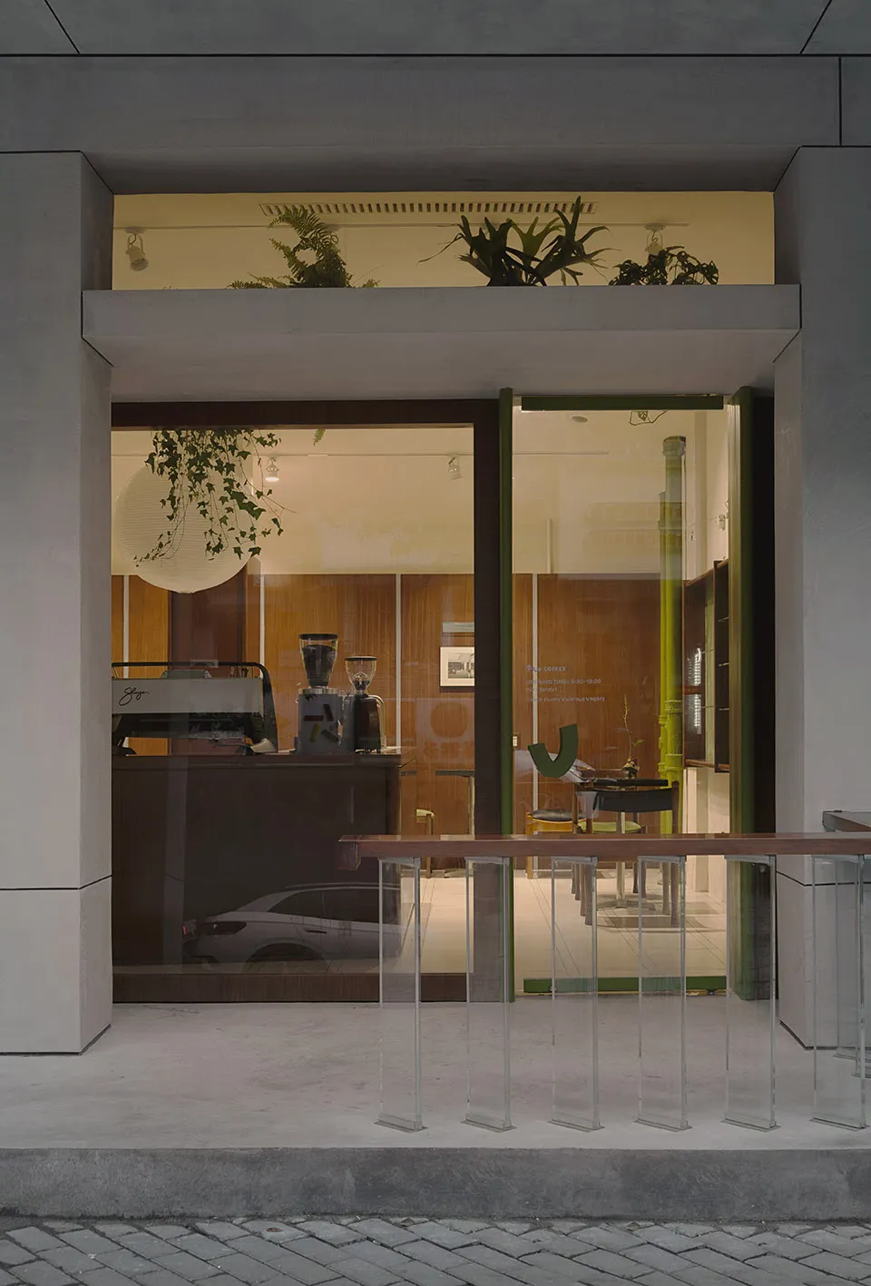 A modern coffee shop with glass and concrete features.