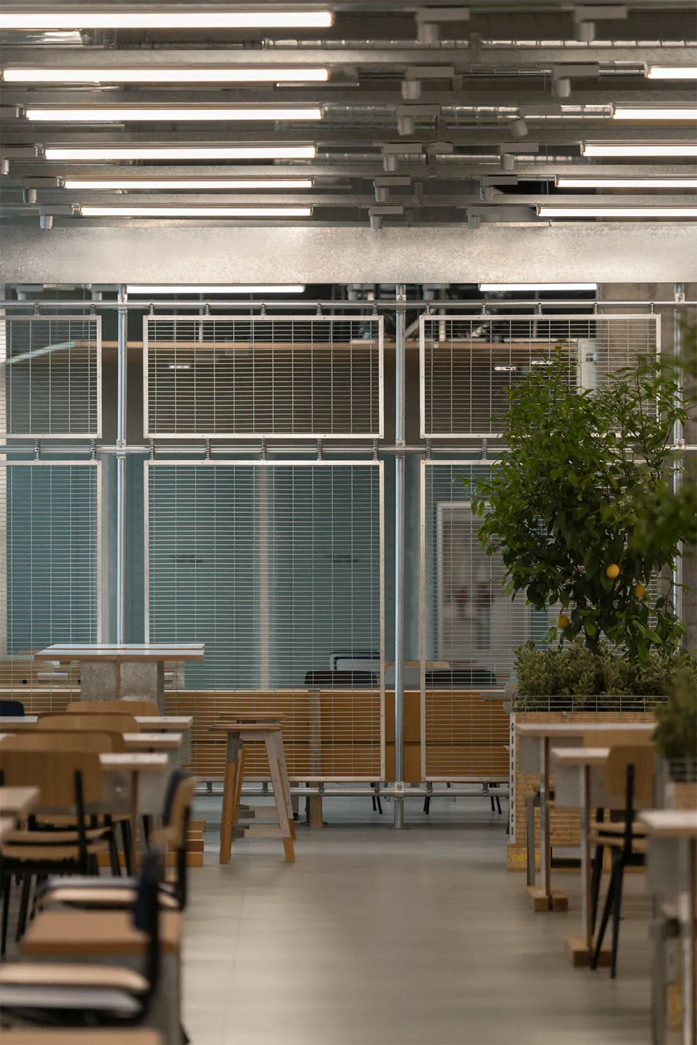 現代餐廳空間,配有金屬家具、白牆與花崗岩地板。