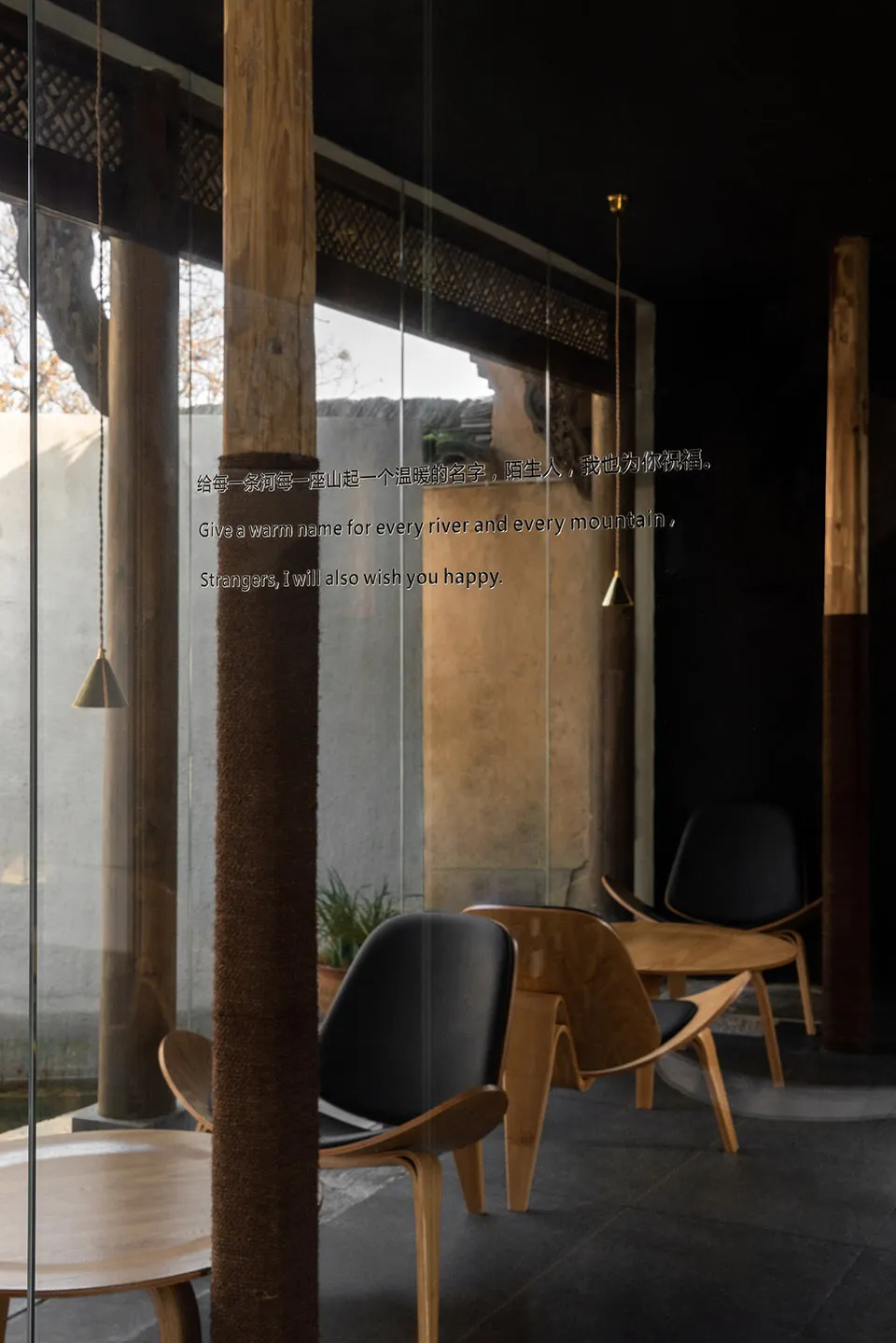 Modern restaurant interior with wooden furniture, black chairs, and glass walls