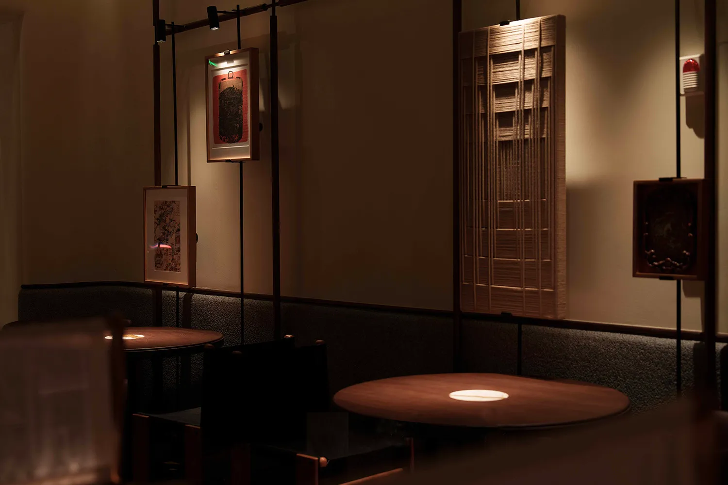A cozy restaurant interior with wooden tables and walls, featuring art displayed on the walls.
