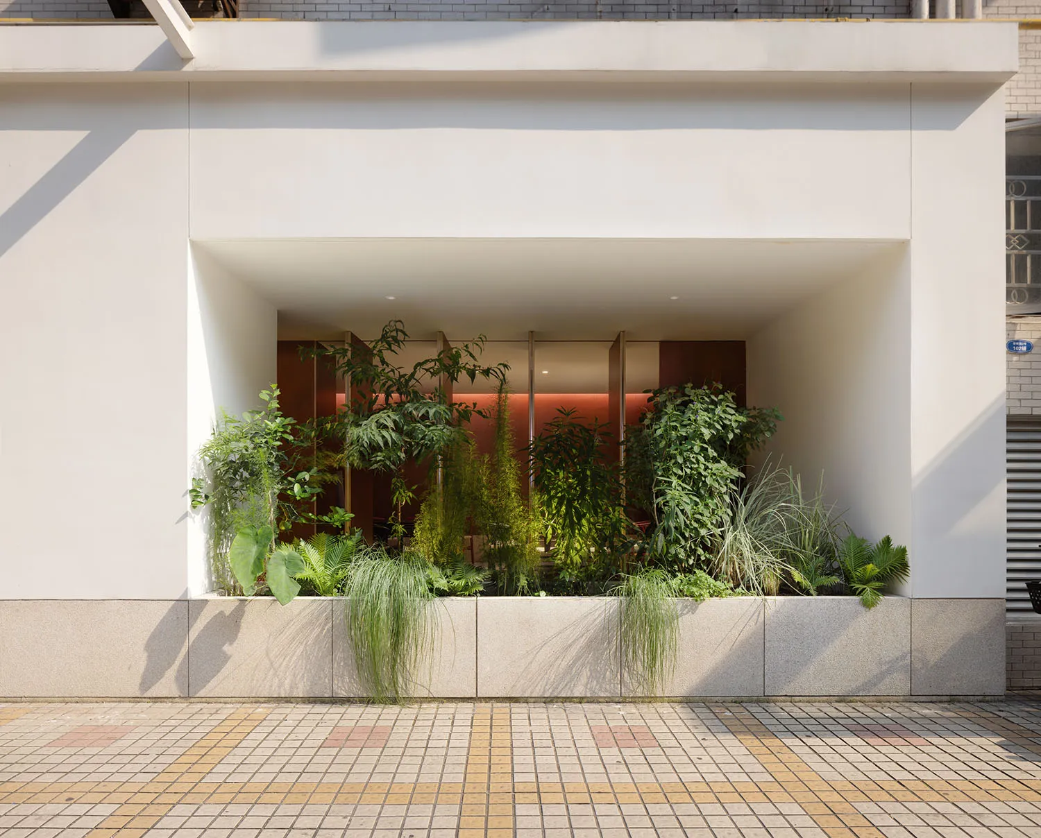 A retail store with a green roof, showcasing vertical gardens and sustainable design features.