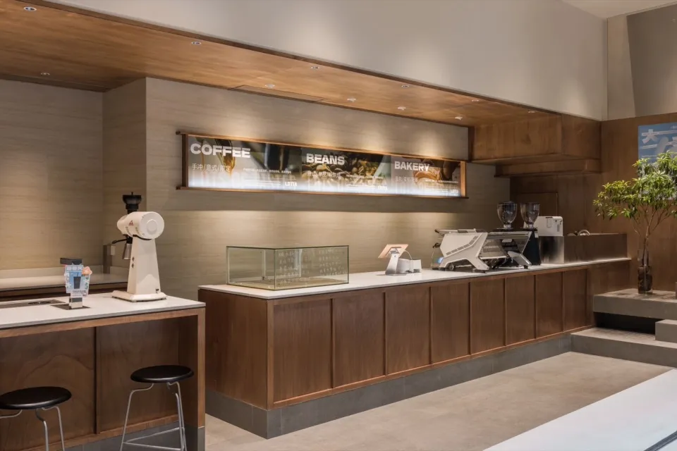 Modern coffee shop with a wooden countertop and stainless steel appliances.