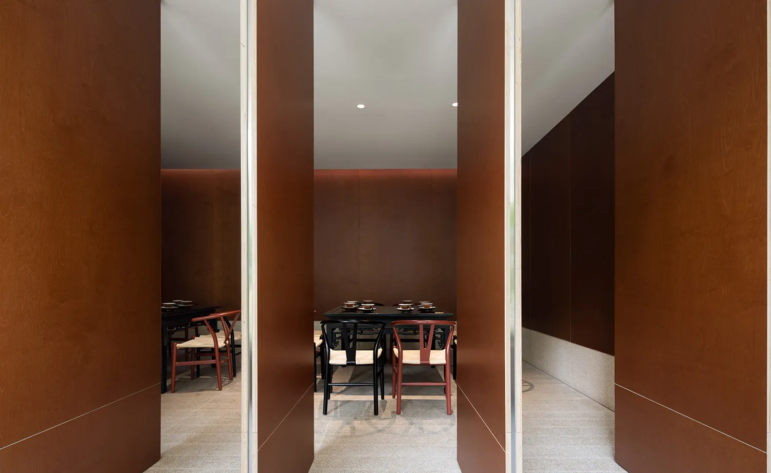 A minimalist restaurant interior with wooden walls and flooring.