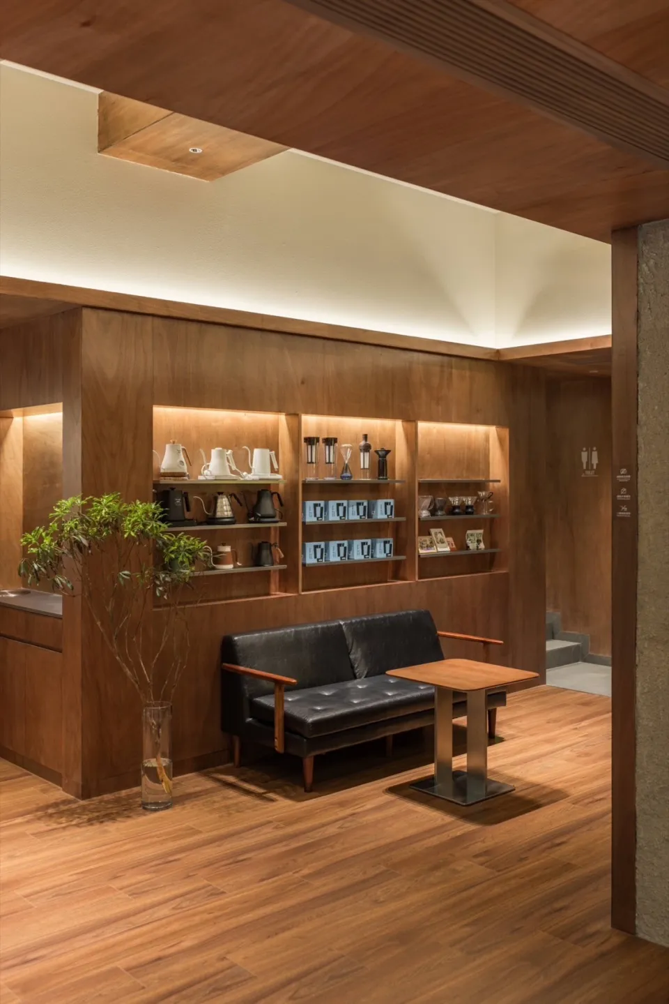 A modern coffee shop featuring wooden interiors and furniture.