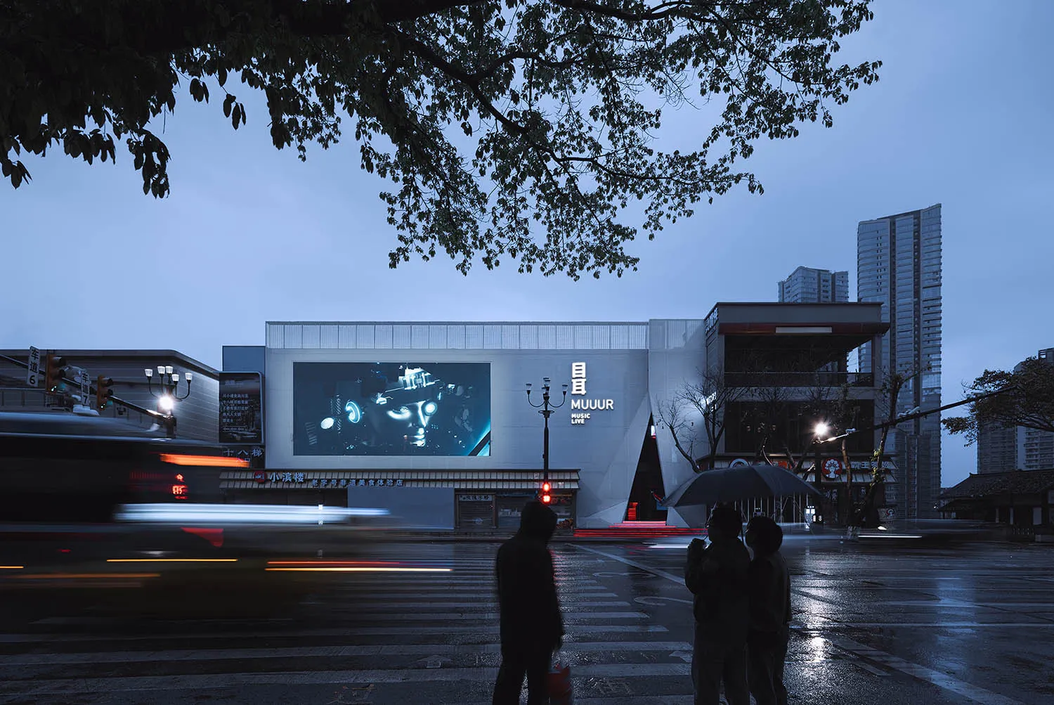 Modern public space with large glass panels, steel framing, and LED lighting.
