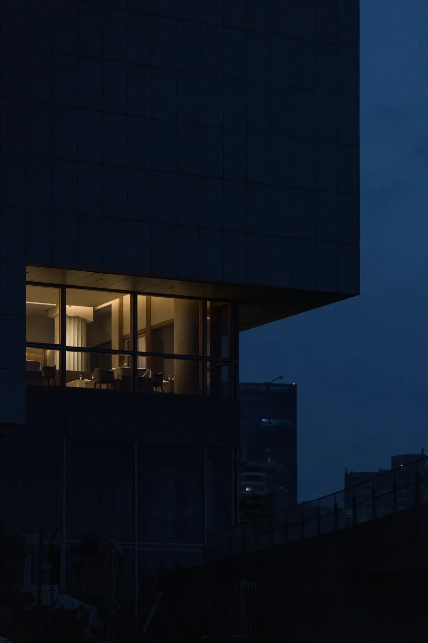 Interior view of modern building with illuminated windows against a dark sky.