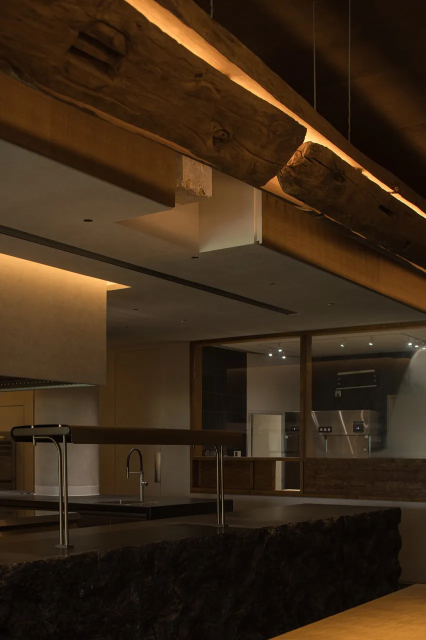 Industrial kitchen featuring reclaimed wood beams and concrete countertops