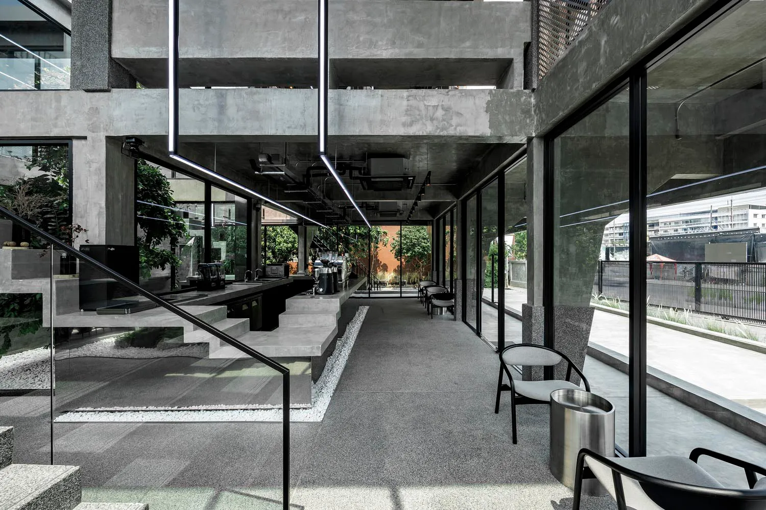 An industrial-style coffee shop with concrete and glass features.