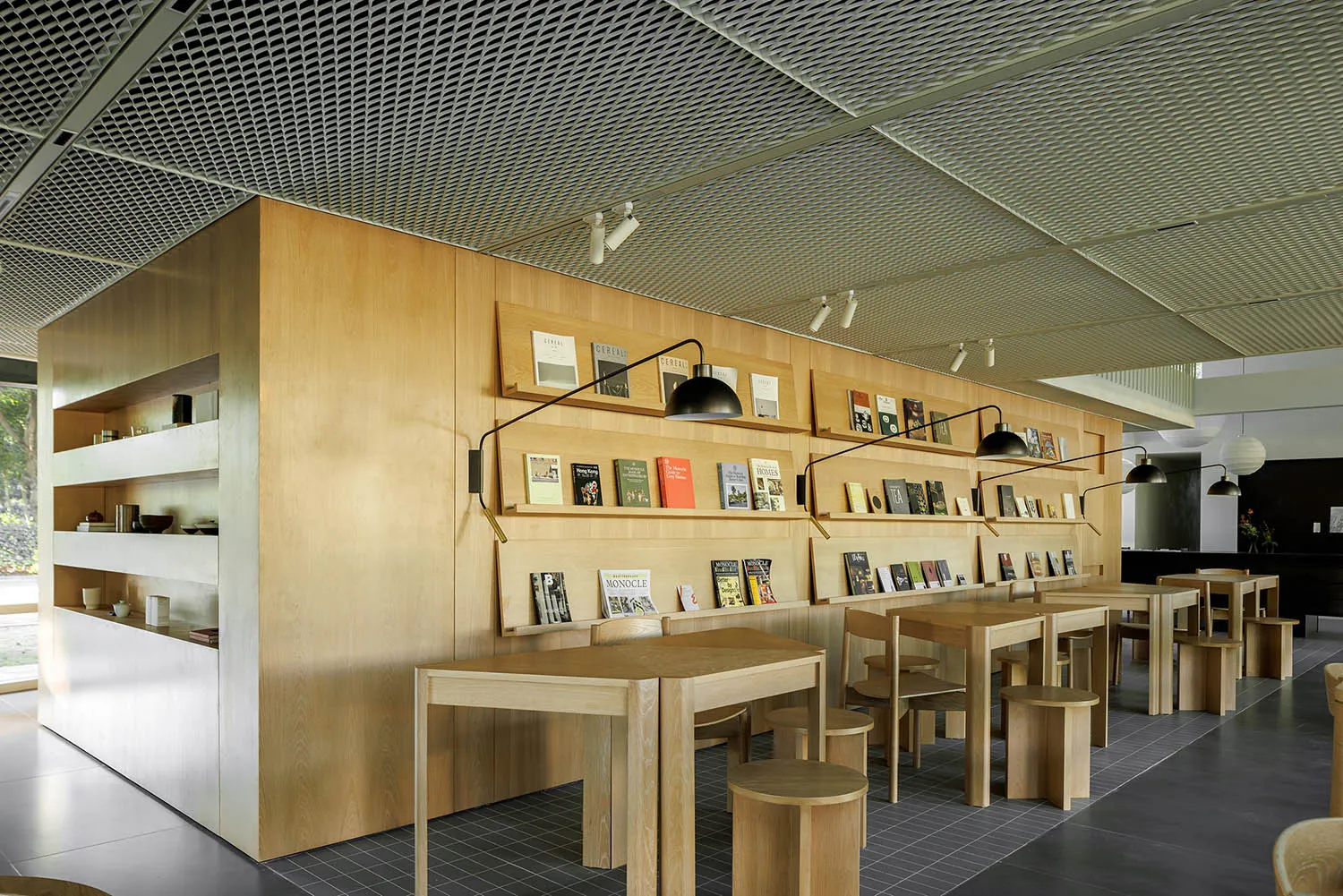 A modern library interior featuring wooden panels and built-in shelves filled with books.