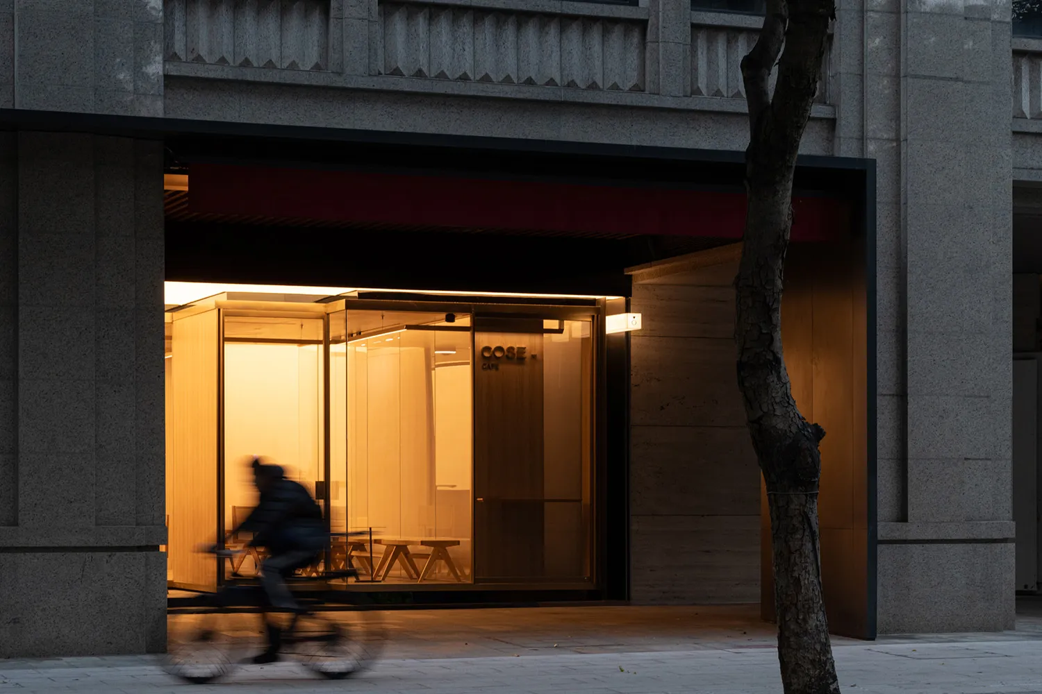 A modern cafe storefront with glass walls and timber elements.