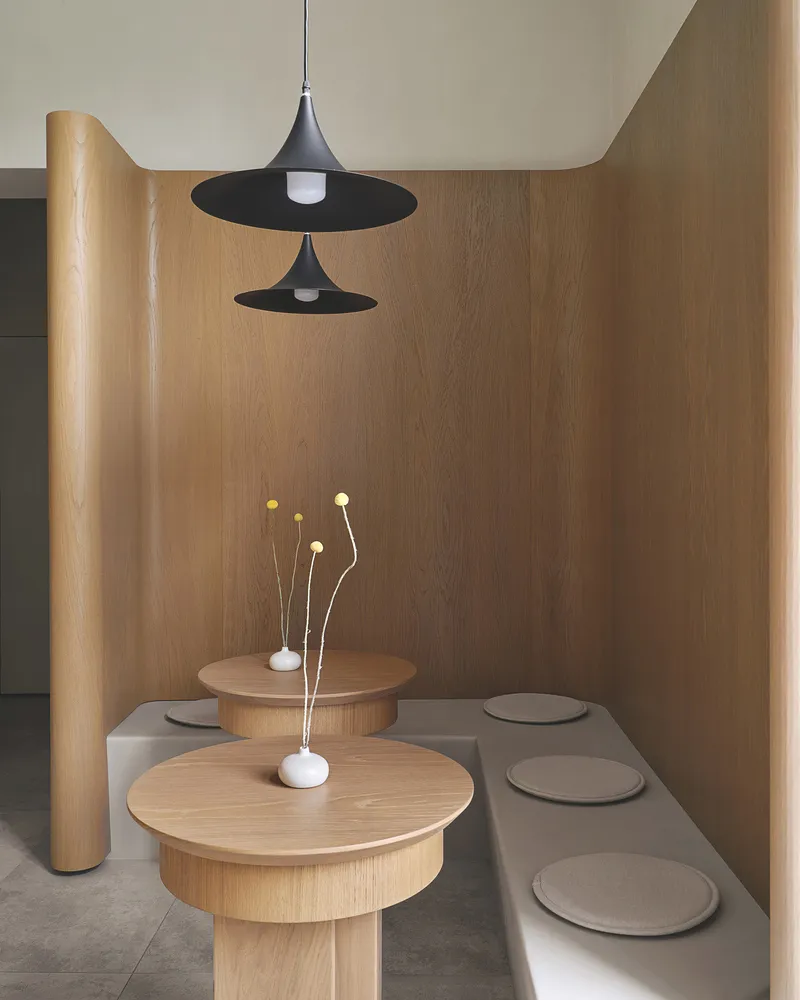 Modern designed restaurant booth seating with concrete flooring and wooden tables and benches.