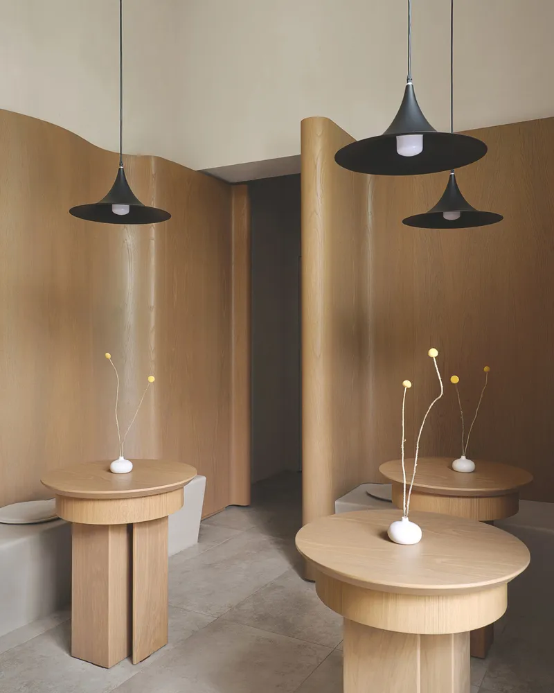 A modern restaurant interior with wooden furniture and minimalist design.