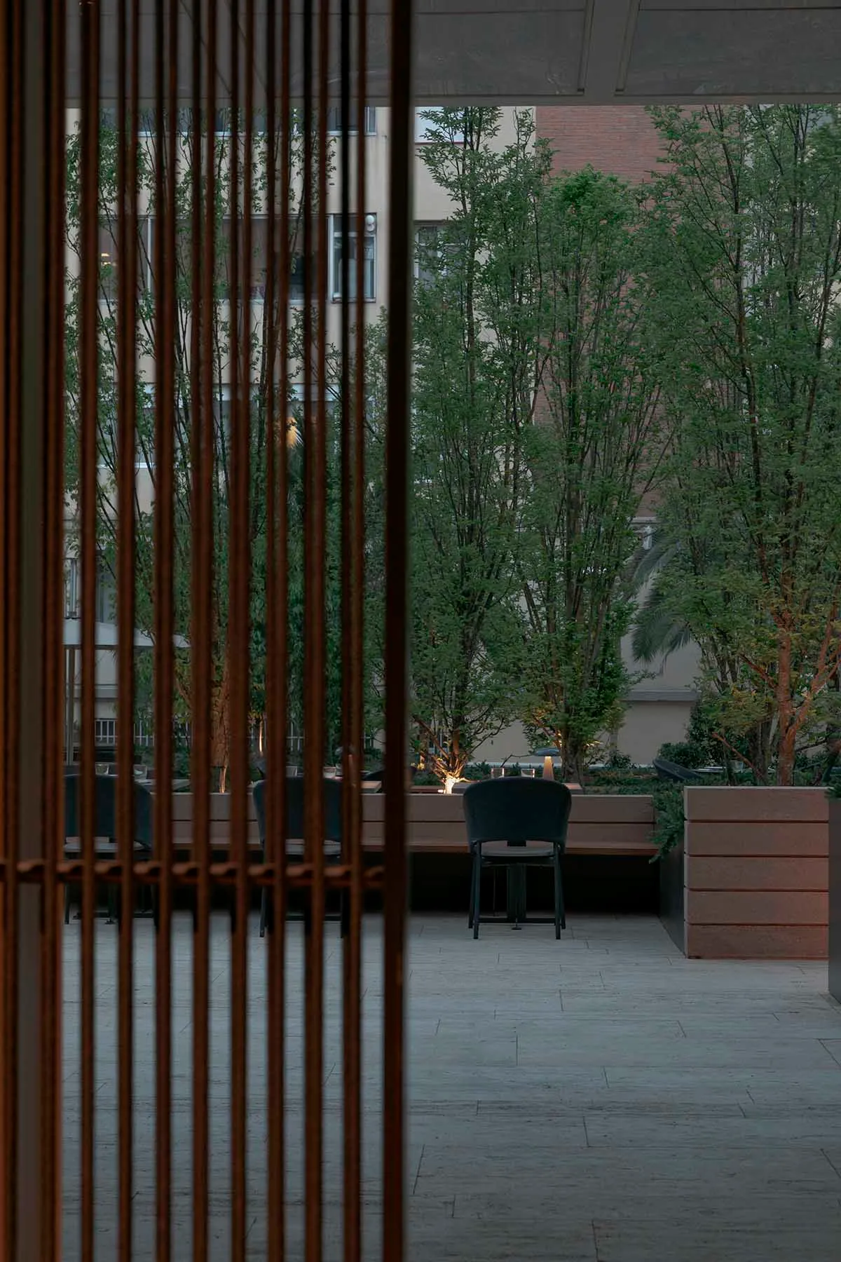 A minimalist outdoor dining area with wooden slats and greenery.