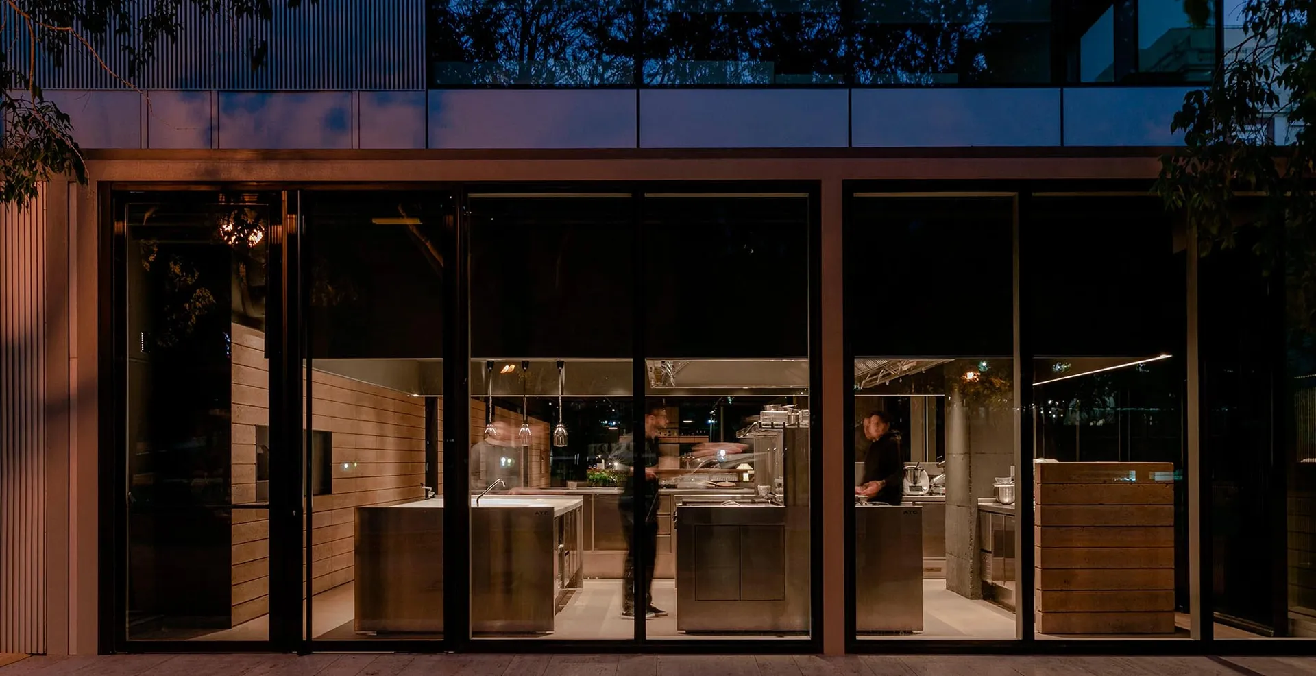A modern cooking area with stainless steel appliances and white countertops.