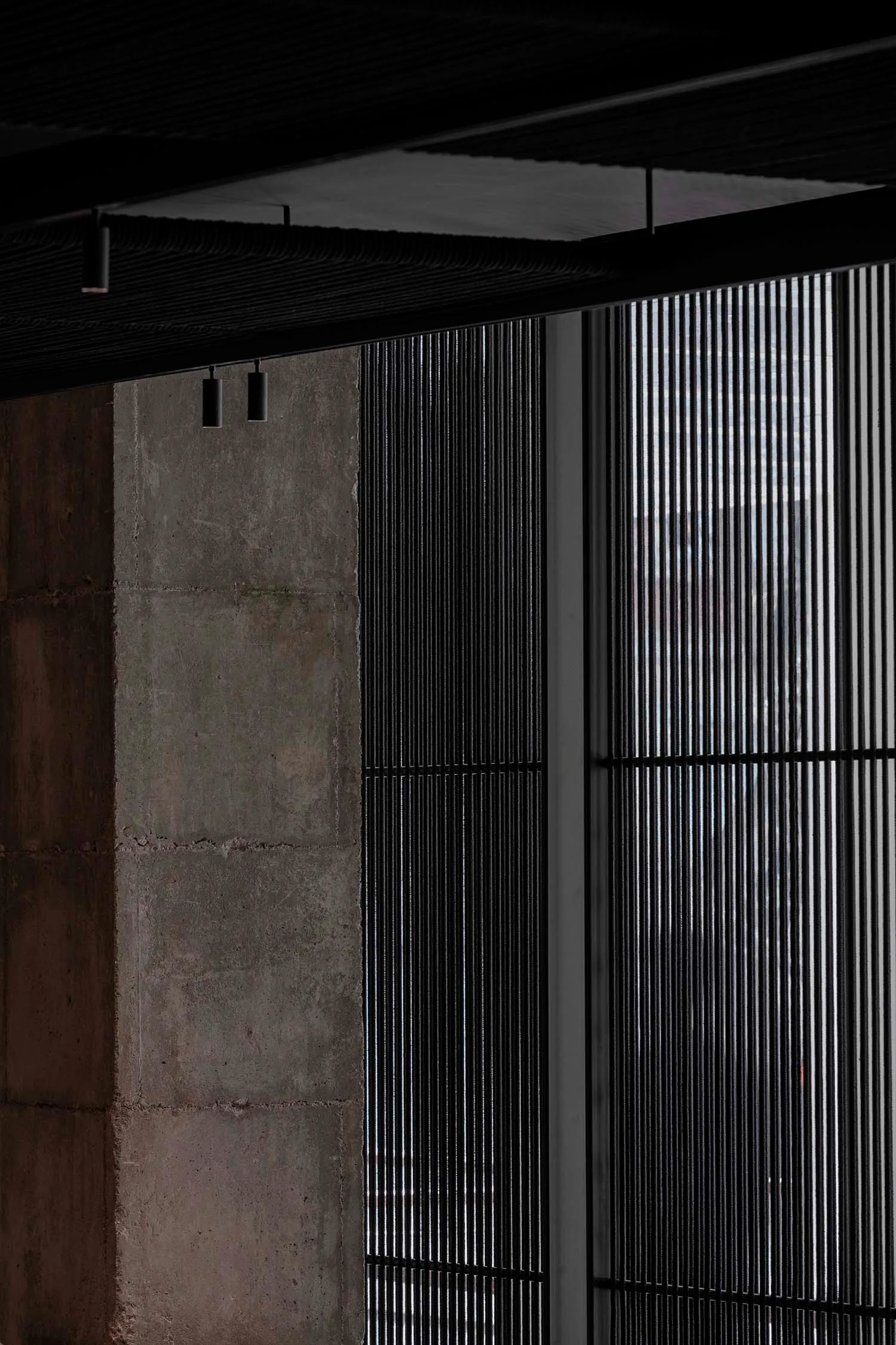 Concrete wall with modern grid pattern and overhead lighting