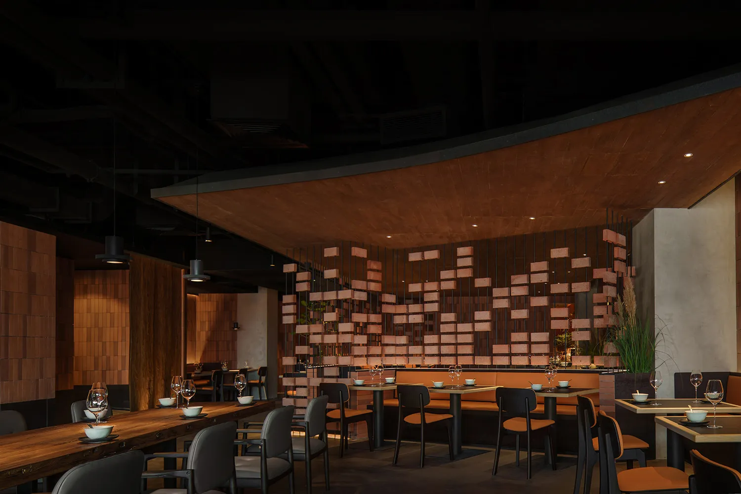 A stylish restaurant interior with brick walls and concrete accents, featuring modern furnishings and dim lighting.