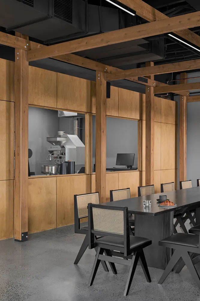 Modern office space with a wooden coffee shop area featuring industrial design elements.