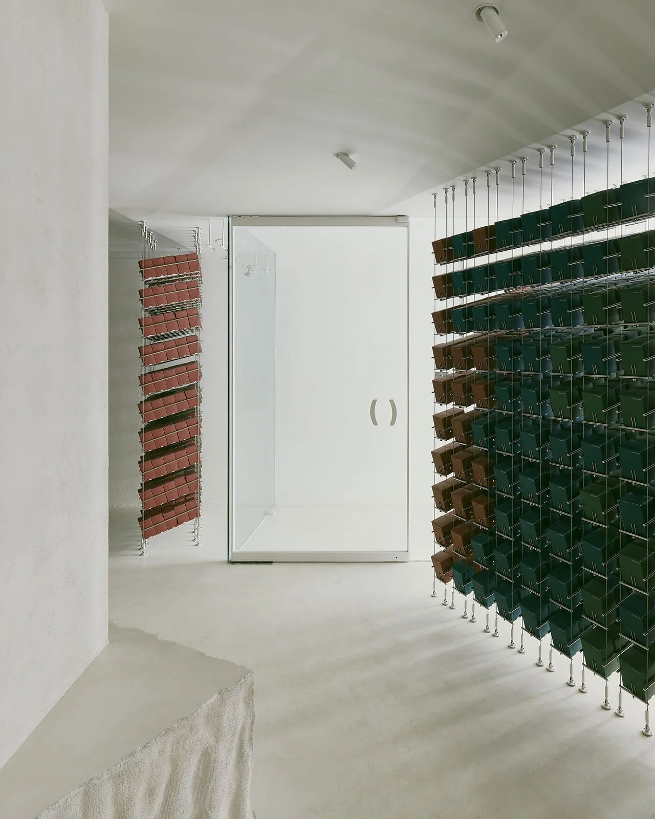A minimalist interior design featuring concrete walls and metal shelving units.