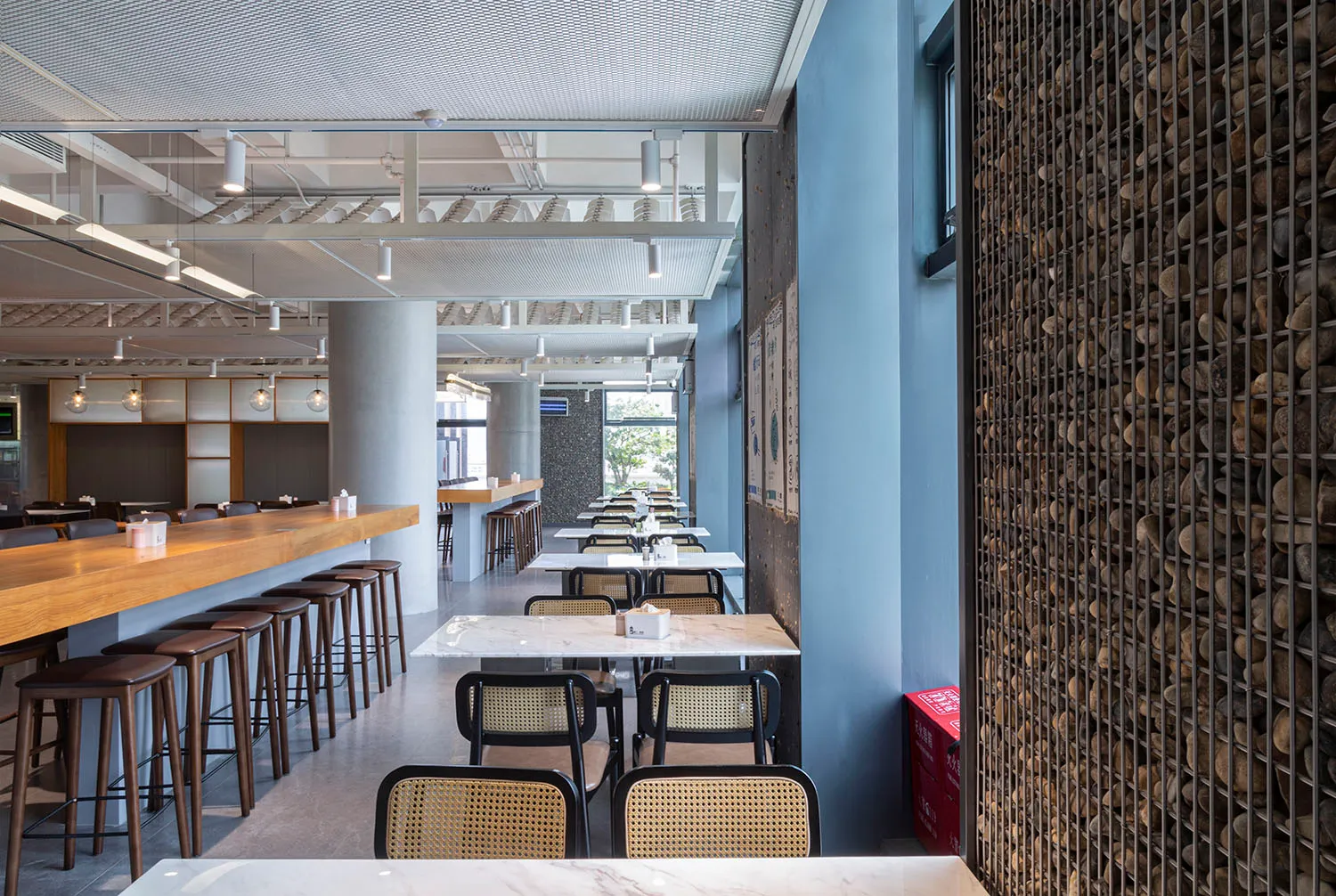 A modern cafe interior featuring minimalist design with concrete elements.