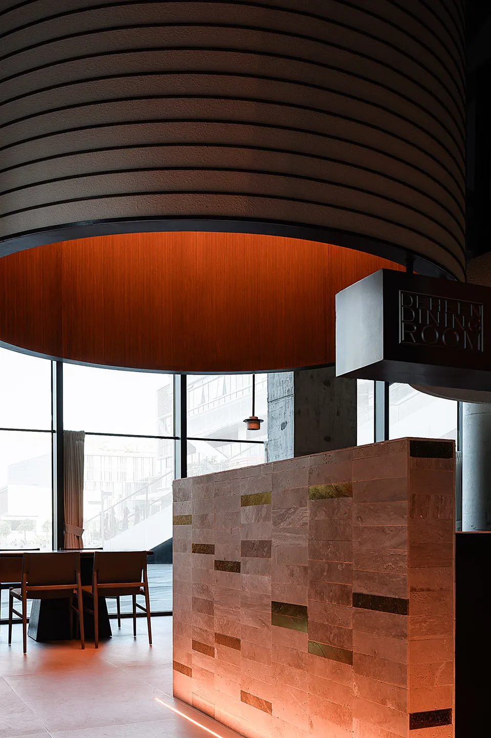 An image of a modern minimalist restaurant interior featuring concrete and brick materials.