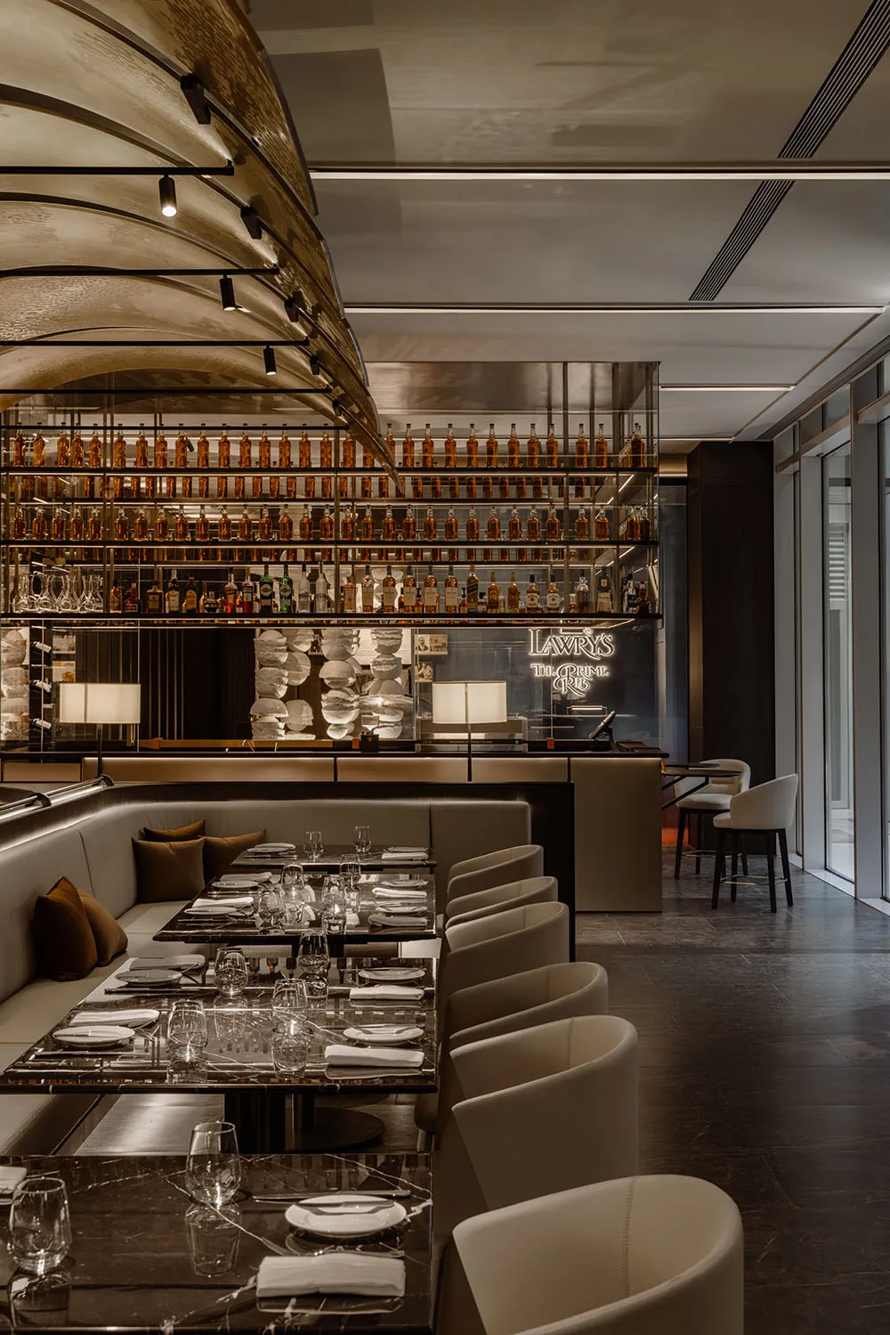 A photograph showcasing a modern luxury restaurant dining interior with metallic elements and leather.