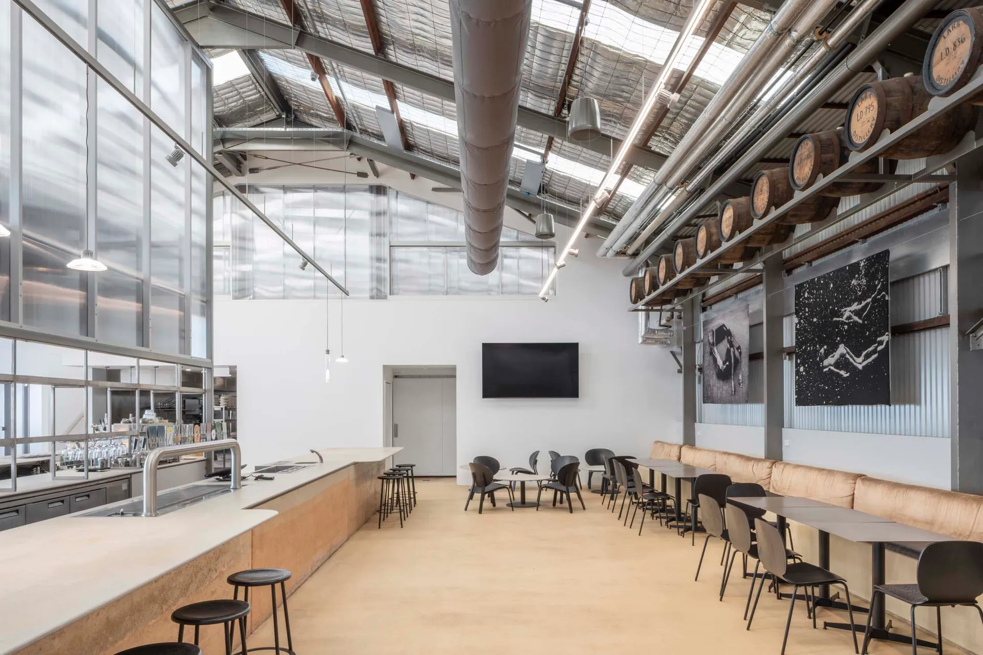 Industrial-style restaurant interior featuring concrete, metal, and glass materials.